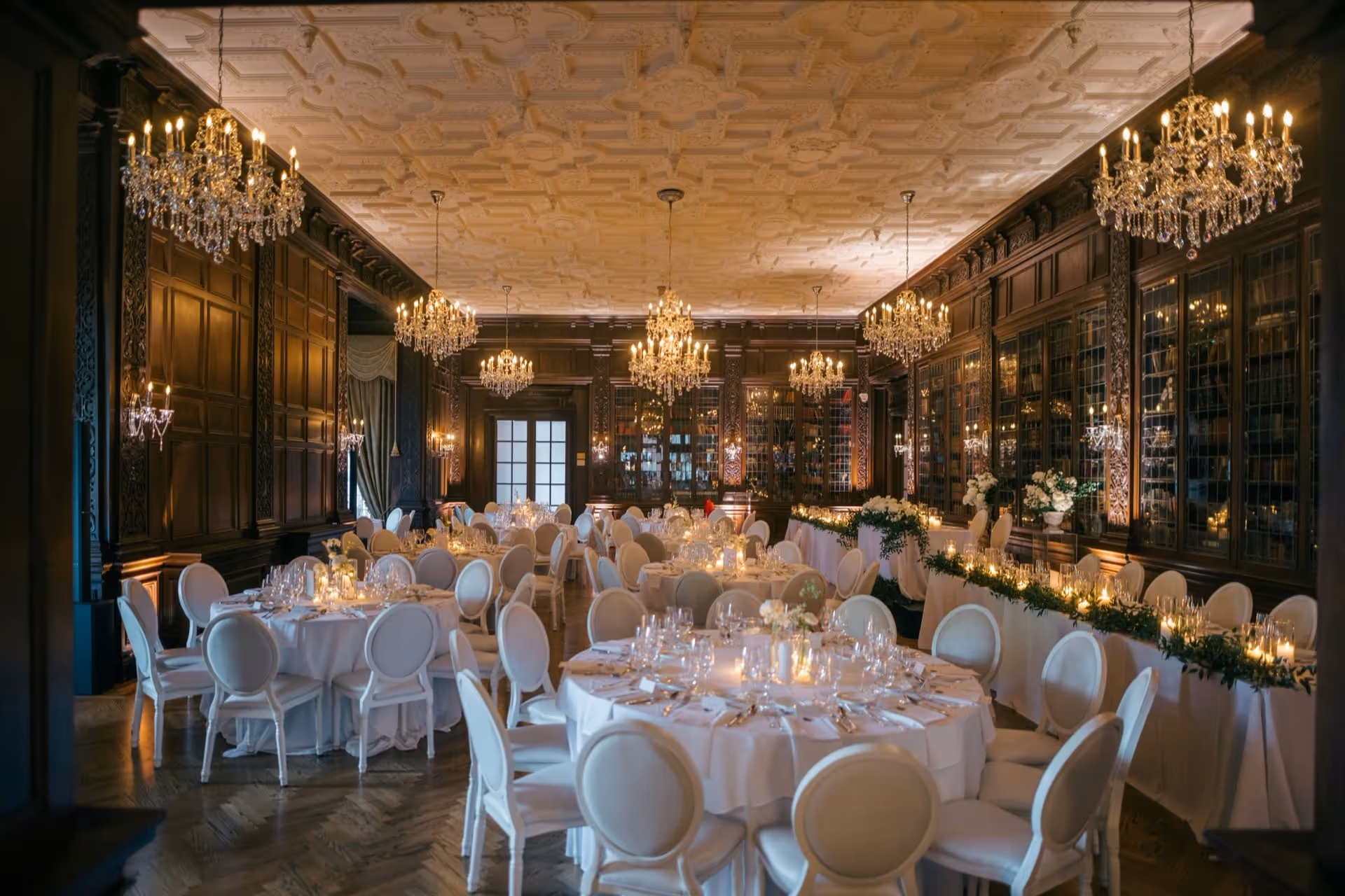 Grand ballroom with crystal chandeliers set for a wedding reception at The Saharsh Pavilion
